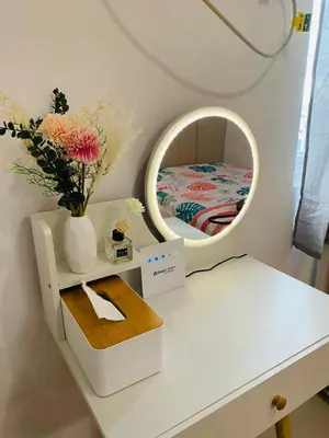 a white dressing table with a mirror and a vase with flowers at Casa Lim SMDC Light Residences Tower 3 in Manila