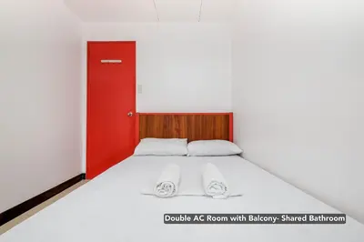 a bedroom with a bed with a red door at Stay Malate (Wanderers Guest House) in Manila