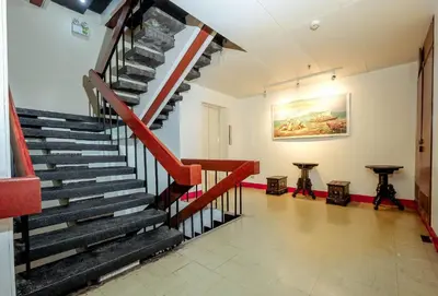 a staircase in a building with a red and black railing at Stay Malate (Wanderers Guest House) in Manila