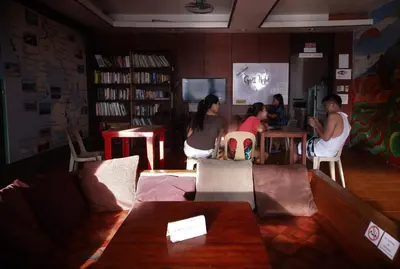 a group of people sitting at a table in a room at Stay Malate (Wanderers Guest House) in Manila