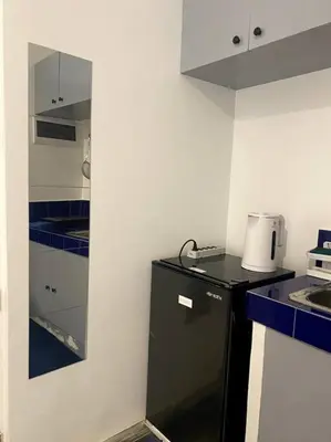 a small kitchen with a black refrigerator and blue counters at El Pueblo Studio - Manila in Manila