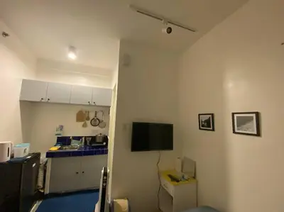 a room with a kitchen and a tv on a wall at El Pueblo Studio - Manila in Manila