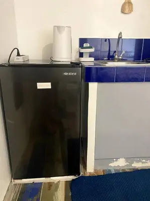 a kitchen with a black dishwasher and a sink at El Pueblo Studio - Manila in Manila