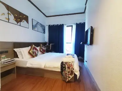 a bedroom with a bed with blue curtains and a television at warm makati in Manila