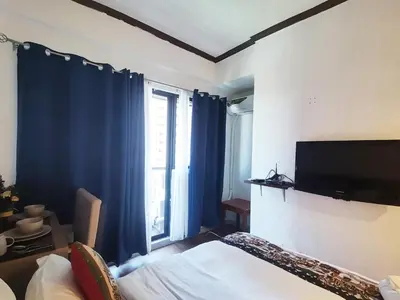 a bedroom with a bed and a flat screen tv at warm makati in Manila