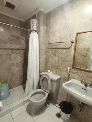 a bathroom with a toilet and a sink at warm makati in Manila