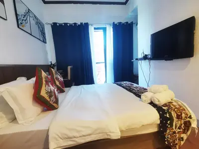 a bedroom with a bed with a tv on the wall at warm makati in Manila