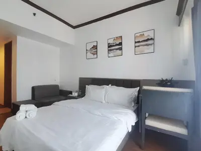a bedroom with a white bed and a desk at passion makati in Manila