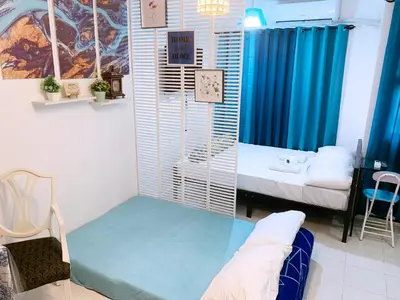 a small room with two beds and a table at Blue Diamond Staycation beside Enchanted Kingdom in Santa Rosa Laguna in Santa Rosa