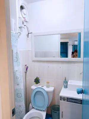 a bathroom with a toilet and a sink and a mirror at Blue Diamond Staycation beside Enchanted Kingdom in Santa Rosa Laguna in Santa Rosa