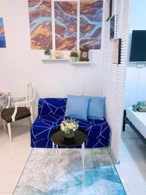 a living room with a blue couch and a table at Blue Diamond Staycation beside Enchanted Kingdom in Santa Rosa Laguna in Santa Rosa