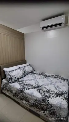 a bedroom with a bed with a black and white comforter at Shore 2 Tower 1 JMB Staycation in Manila