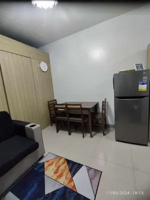 a living room with a table and a refrigerator at Shore 2 Tower 1 JMB Staycation in Manila