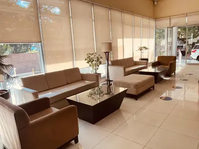 a living room with couches and tables and windows at Condo near UP-PGH, St. Lukes Medical Center and U.S Embassy in Ermita Manila in Manila