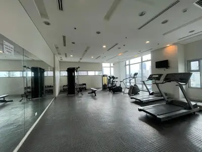 a gym with cardio equipment in a large room at Condo near UP-PGH, St. Lukes Medical Center and U.S Embassy in Ermita Manila in Manila