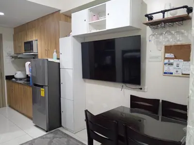 a kitchen with a refrigerator and a table with chairs at The SPARKLE Comfortable living by Awsom Phil in Manila