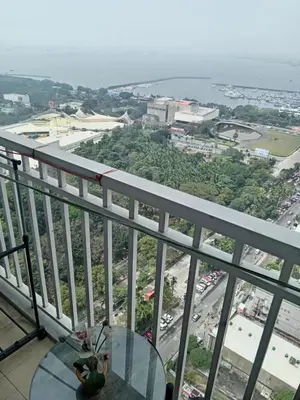 a balcony with a table and a view of a city at The SPARKLE Comfortable living by Awsom Phil in Manila