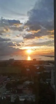 a sunset over a city with the sun in the sky at The SPARKLE Comfortable living by Awsom Phil in Manila