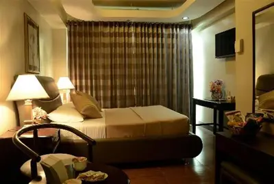 a hotel room with a bed and a window at Silver Oaks Suites & Hotel in Manila