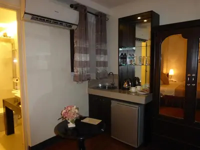 a bathroom with a sink and a table in a room at Silver Oaks Suites & Hotel in Manila