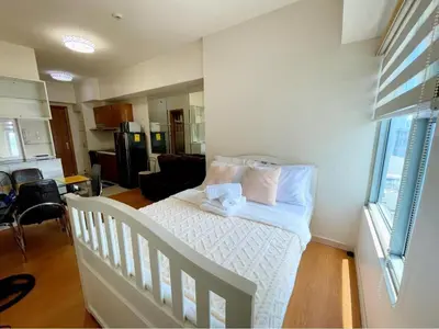 a bedroom with a bed with white sheets and pillows at Condo for Short Stay in Ermita near SLMEC & US Embassy in Manila