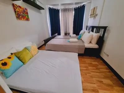 a living room with two beds and a couch at Newport's STAR at Montecito Residential Resort in Manila