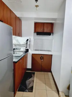 a small kitchen with a sink and a refrigerator at Newport's STAR at Montecito Residential Resort in Manila
