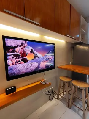 a flat screen tv hanging on a wall at Sea Residences 5mins walk to SM MoA, Arena, SMX, 55