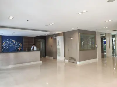 a lobby with a person standing at a counter in a building at Sea Residences 5mins walk to SM MoA, Arena, SMX, 55