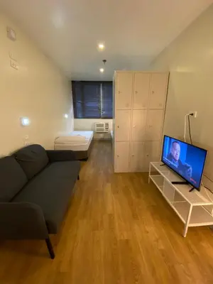 a living room with a couch and a flat screen tv at Burgos Hub Hostel in Manila