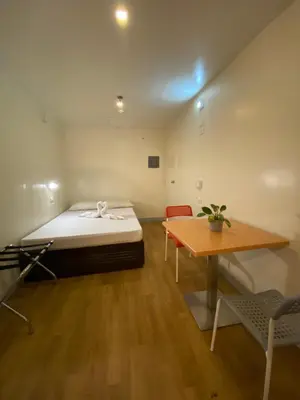 a small room with a bed and a table at Burgos Hub Hostel in Manila