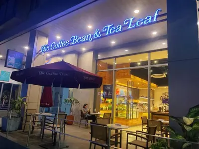 a restaurant with tables and chairs and an umbrella at Luxury Studio in heart of Ortigas w/ swimming pool in Manila
