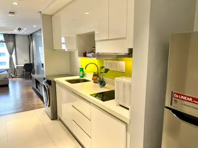 a kitchen with white cabinets and a yellow wall at Luxury Studio in heart of Ortigas w/ swimming pool in Manila