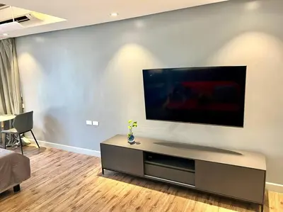 a living room with a flat screen tv on a wall at Luxury Studio in heart of Ortigas w/ swimming pool in Manila