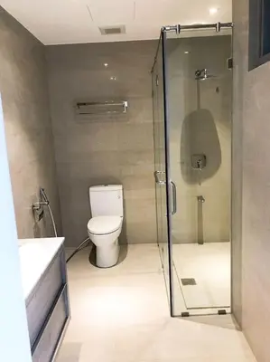 a bathroom with a toilet and a glass shower at 3BR luxury apartment in Ortigas with swimming pool in Manila