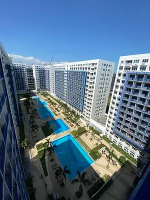 an aerial view of a resort with a pool and buildings at Sea Residences MOA by Ruffa's Condotel in Manila