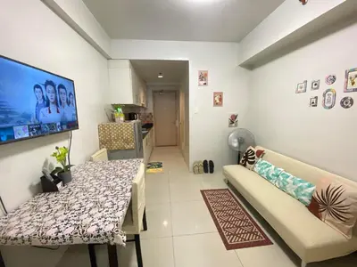 a living room with a table and a couch at Sea Residences MOA by Ruffa's Condotel in Manila