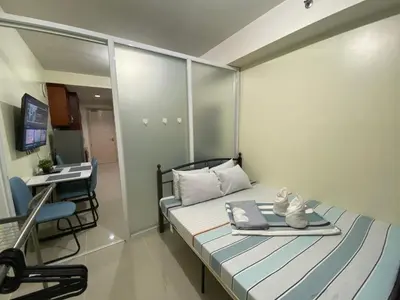 a small room with a bed and a chair at Sea Residences MOA by Ruffa's Condotel in Manila