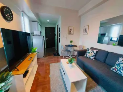 a living room with a blue couch and a table at Air Residences Makati - fully furnished condo with skyline views! in Manila