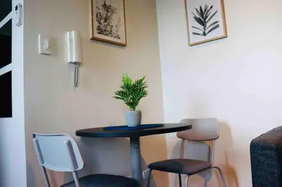 a table with two chairs and a potted plant on it at Air Residences Makati - fully furnished condo with skyline views! in Manila