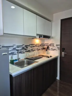 a kitchen with white cabinets and a sink at Air Residences Makati - fully furnished condo with skyline views! in Manila