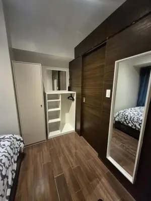 a small bedroom with a bed and a mirror at Air Residences Makati - fully furnished condo with skyline views! in Manila