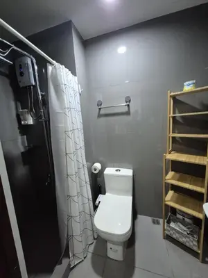a bathroom with a white toilet and a shower at Air Residences Makati - fully furnished condo with skyline views! in Manila