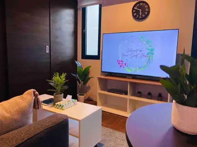 a living room with a tv and a couch and a table at Air Residences Makati - fully furnished condo with skyline views! in Manila
