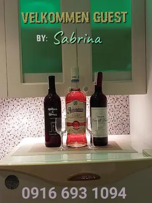 two bottles of wine sitting on a shelf with glasses at Condo near NAIA Terminals Fasanvej Studio Netflix in Manila