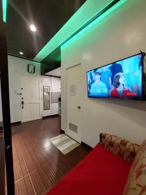 a living room with a flat screen tv on a wall at Condo near NAIA Terminals Fasanvej Studio Netflix in Manila