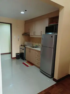 a kitchen with a stainless steel refrigerator and cabinets at 20h staycation away from home in Manila
