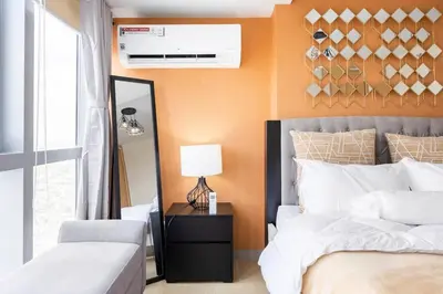 a bedroom with two beds and a lamp on a table at Luxury living @ Eastwood in Manila