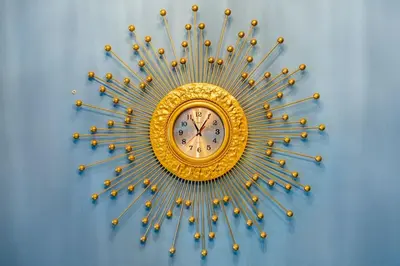 a gold sunburst clock on a blue wall at Luxury living @ Eastwood in Manila