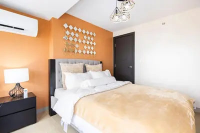 a bedroom with a large bed with orange walls at Luxury living @ Eastwood in Manila